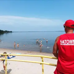 Ratownik czuwa nad bezpieczeństwem kąpiących się. Na plaży i w wodzie liczne atrakcje dla wypoczywających.