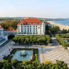 Spacerem po bulwarze nadmorskim, z widokiem na hotel, plażę i morze.