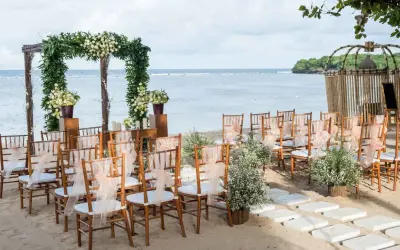 Ustawione krzesła i łuk z kwiatami czekają na ślub na plaży. Romantyczna sceneria nad morzem.