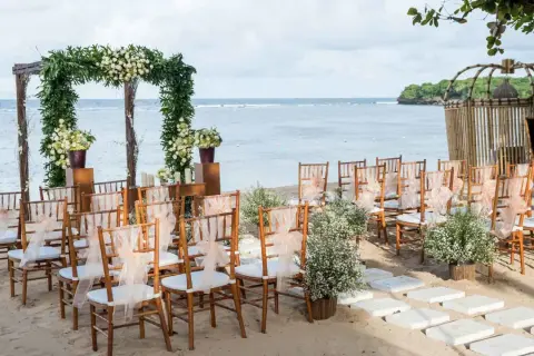 Ustawione krzesła i łuk z kwiatami czekają na ślub na plaży. Romantyczna sceneria nad morzem.