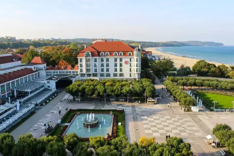 Spacerem po bulwarze nadmorskim, z widokiem na hotel, plażę i morze.