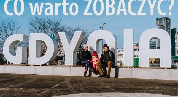 Rodzina pozuje na tle napisu GDYNIA. Idealne miejsce na weekendowe atrakcje w Gdyni.