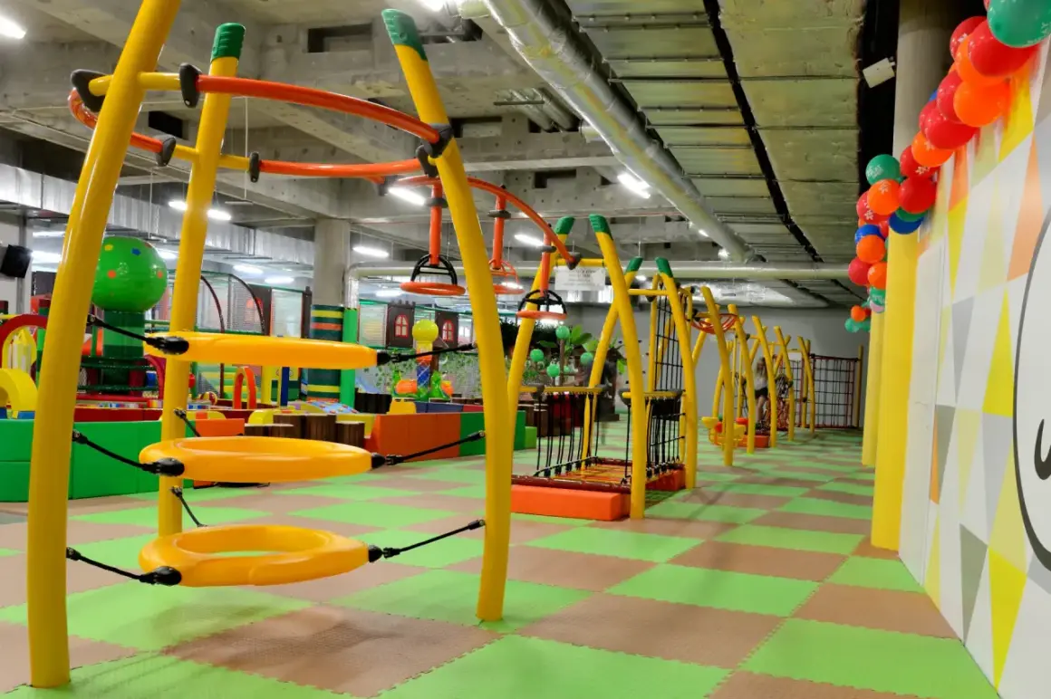 Kolorowa, wielopoziomowa sala zabaw w **fun arena Gdańsk** z żółtymi konstrukcjami, huśtawkami i zieloną podłogą.