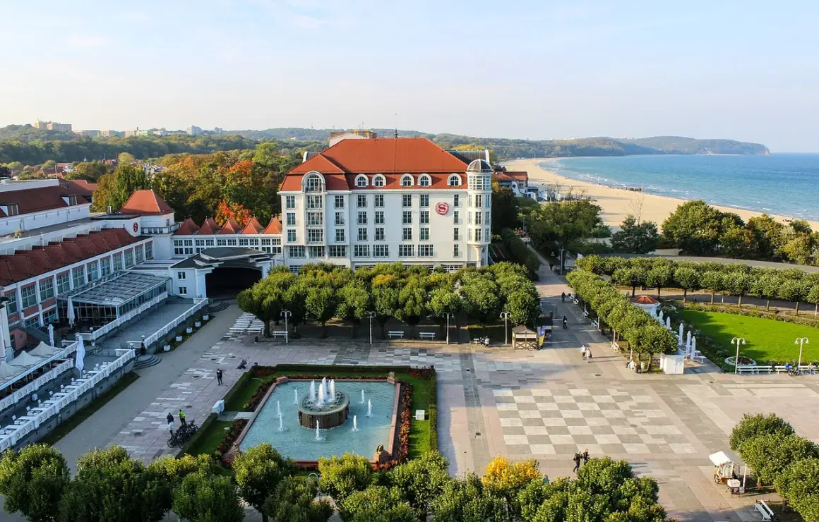Spacerem po bulwarze nadmorskim, z widokiem na hotel, plażę i morze.