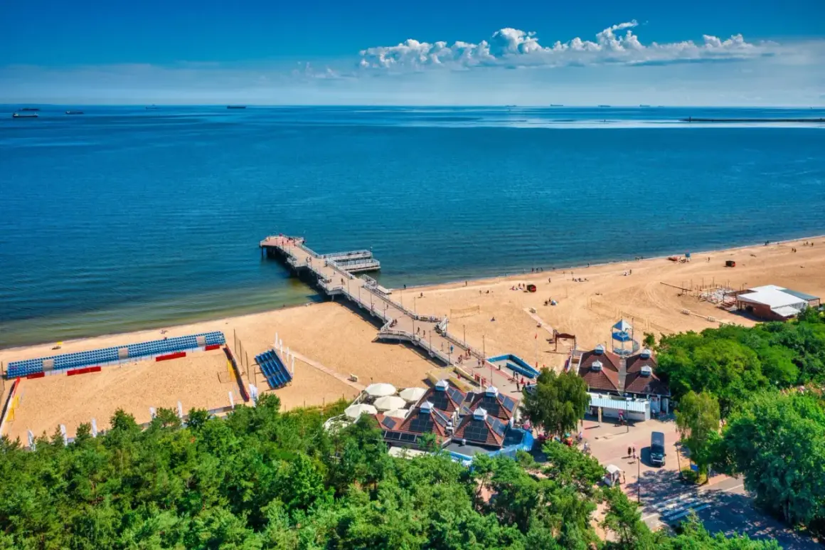 Molo w Brzeźnie, plaża i budynki z zielenią tworzą piękne gdańsk brzeźno atrakcje.