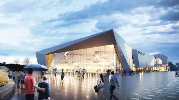 Nowoczesny budynek oceanarium Gdańsk z napisem "Nautilus Gdańsk" i logo delfina. Ludzie spacerują po placu przed budynkiem.